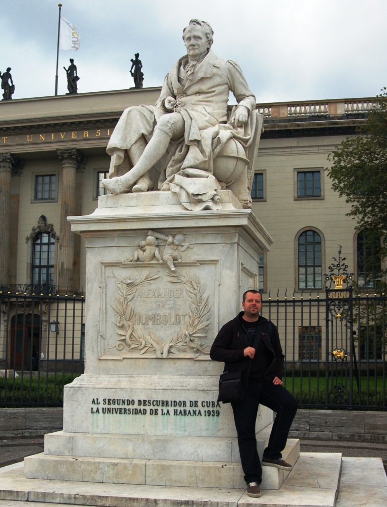 Young man student in front of Humboldt statue, Humboldt University, Berlin Germany 