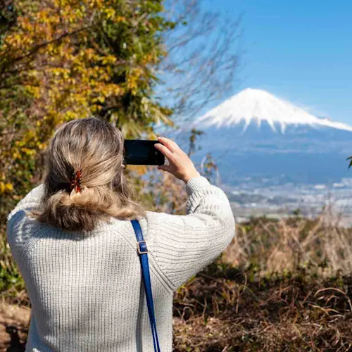 Woman-taking-a-photo-of-Mount-Fuji-with-an-aerial-view-of-Fuji-City