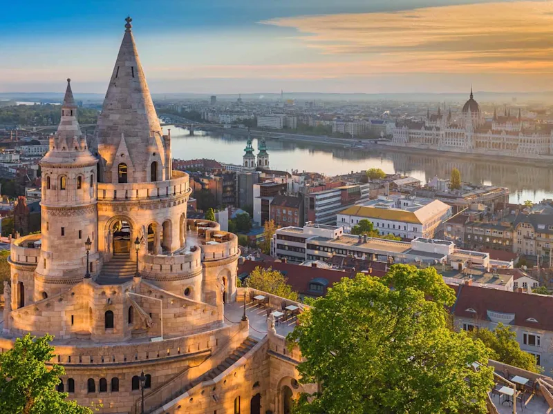 Budapest Hungary - Beautiful golden summer sunrise with the tower of Fisherman-s Bastion and green trees. Parliament of Hun