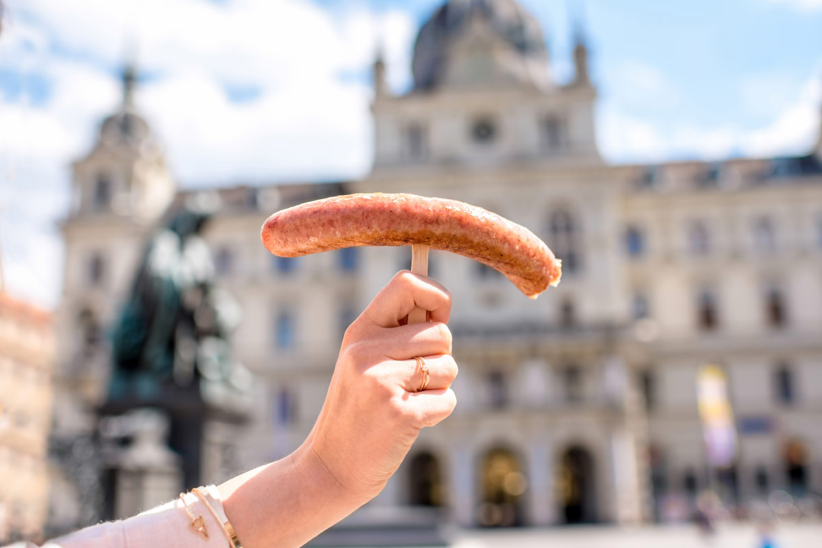 Woman holding wurstel in Vienna, Austria food bucket list